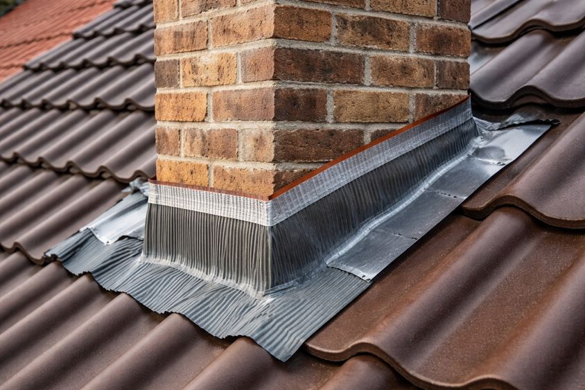 Obróbka komina na dachu: fartuchy, taśmy, kołnierze – co działa najlepiej?